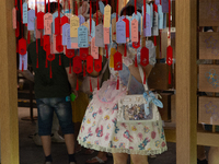 A woman is placing her wish at Yu Garden during Qixi, a Chinese traditional Valentine, in Shanghai, China, on August 10, 2024. (