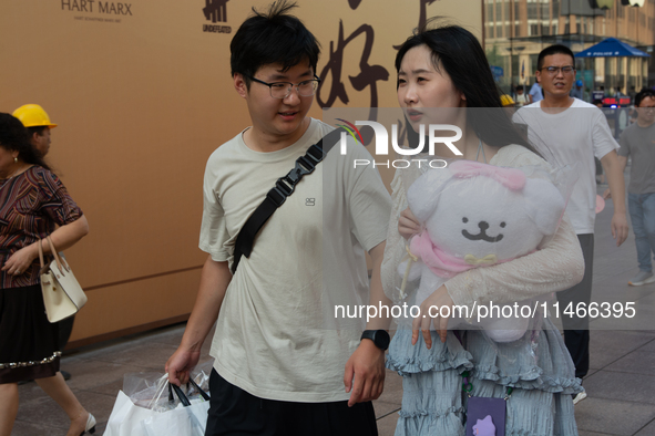 A young couple is being seen on Nanjing Road during Qixi, a Chinese traditional Valentine, in Shanghai, China, on August 10, 2024. 