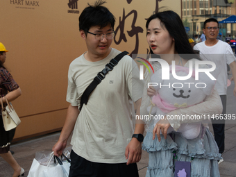 A young couple is being seen on Nanjing Road during Qixi, a Chinese traditional Valentine, in Shanghai, China, on August 10, 2024. (