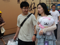 A young couple is being seen on Nanjing Road during Qixi, a Chinese traditional Valentine, in Shanghai, China, on August 10, 2024. (