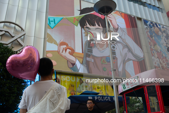 A young man is holding a heart balloon on Nanjing Road during Qixi, a Chinese traditional Valentine, in Shanghai, China, on August 10, 2024....