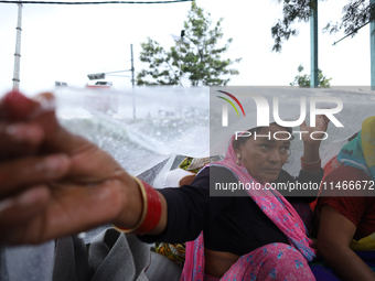 A group of human rights activists are taking shelter under plastic sheets as it is raining heavily during a sit-in protest in Kathmandu, Nep...