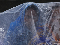 A group of human rights activists are taking shelter under plastic sheets as it is raining heavily during a sit-in protest in Kathmandu, Nep...