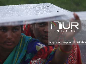 A group of human rights activists are taking shelter under plastic sheets as it is raining heavily during a sit-in protest in Kathmandu, Nep...