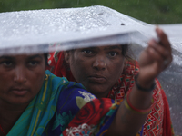 A group of human rights activists are taking shelter under plastic sheets as it is raining heavily during a sit-in protest in Kathmandu, Nep...