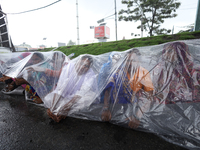 A group of human rights activists are taking shelter under plastic sheets as it is raining heavily during a sit-in protest in Kathmandu, Nep...