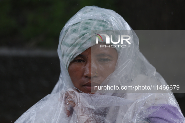 A group of human rights activists are taking shelter under plastic sheets as it is raining heavily during a sit-in protest in Kathmandu, Nep...