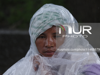 A group of human rights activists are taking shelter under plastic sheets as it is raining heavily during a sit-in protest in Kathmandu, Nep...