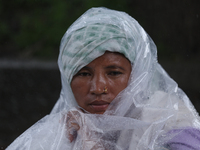 A group of human rights activists are taking shelter under plastic sheets as it is raining heavily during a sit-in protest in Kathmandu, Nep...