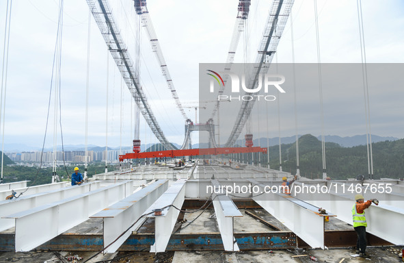 Workers are working at the construction site of Jinzhou Bridge in Xingyi, China, on August 11, 2024. 