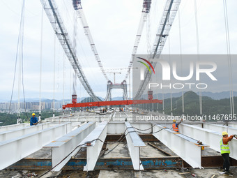 Workers are working at the construction site of Jinzhou Bridge in Xingyi, China, on August 11, 2024. (