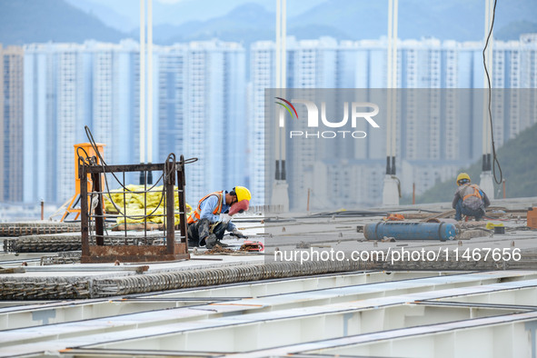 Workers are working at the construction site of Jinzhou Bridge in Xingyi, China, on August 11, 2024. 