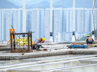 Workers are working at the construction site of Jinzhou Bridge in Xingyi, China, on August 11, 2024. (