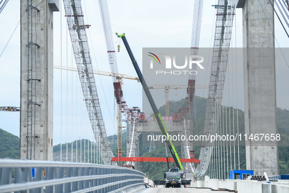 Workers are working at the construction site of Jinzhou Bridge in Xingyi, China, on August 11, 2024. 