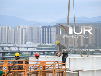 Workers are working at the construction site of Jinzhou Bridge in Xingyi, China, on August 11, 2024. (