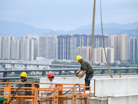 Workers are working at the construction site of Jinzhou Bridge in Xingyi, China, on August 11, 2024. (