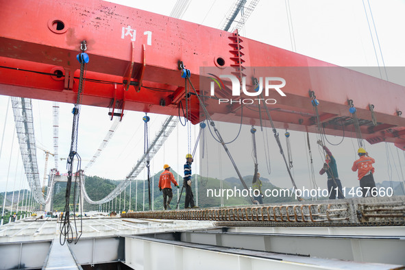 Workers are working at the construction site of Jinzhou Bridge in Xingyi, China, on August 11, 2024. 