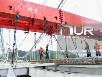 Workers are working at the construction site of Jinzhou Bridge in Xingyi, China, on August 11, 2024. (