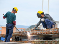 Workers are working at the construction site of Jinzhou Bridge in Xingyi, China, on August 11, 2024. (