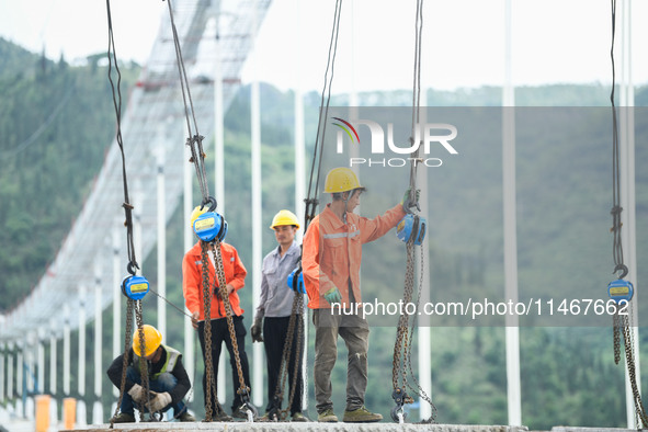 Workers are working at the construction site of Jinzhou Bridge in Xingyi, China, on August 11, 2024. 