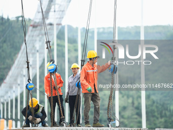 Workers are working at the construction site of Jinzhou Bridge in Xingyi, China, on August 11, 2024. (