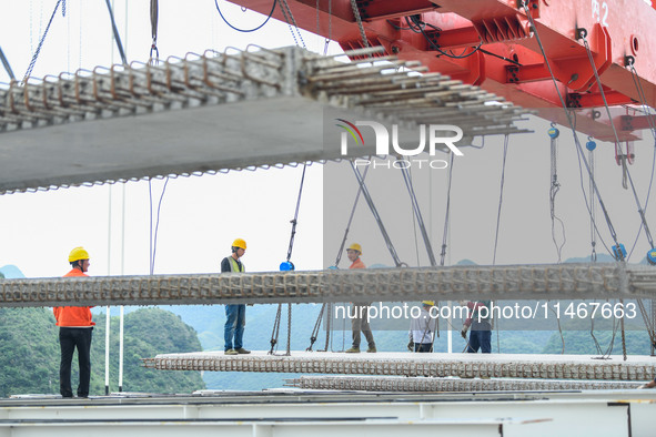 Workers are working at the construction site of Jinzhou Bridge in Xingyi, China, on August 11, 2024. 