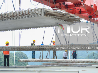 Workers are working at the construction site of Jinzhou Bridge in Xingyi, China, on August 11, 2024. (