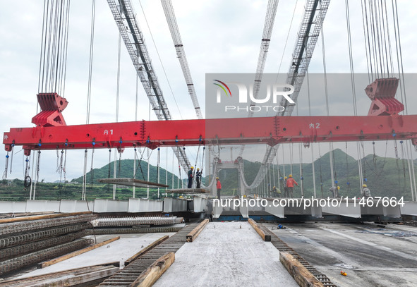 Workers are working at the construction site of Jinzhou Bridge in Xingyi, China, on August 11, 2024. 