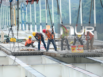 Workers are working at the construction site of Jinzhou Bridge in Xingyi, China, on August 11, 2024. (