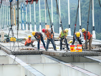 Workers are working at the construction site of Jinzhou Bridge in Xingyi, China, on August 11, 2024. (