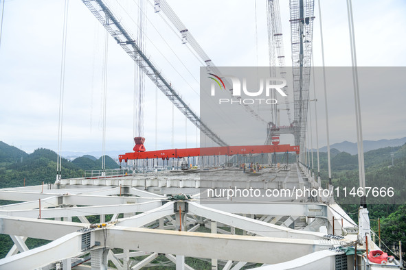 Workers are working at the construction site of Jinzhou Bridge in Xingyi, China, on August 11, 2024. 