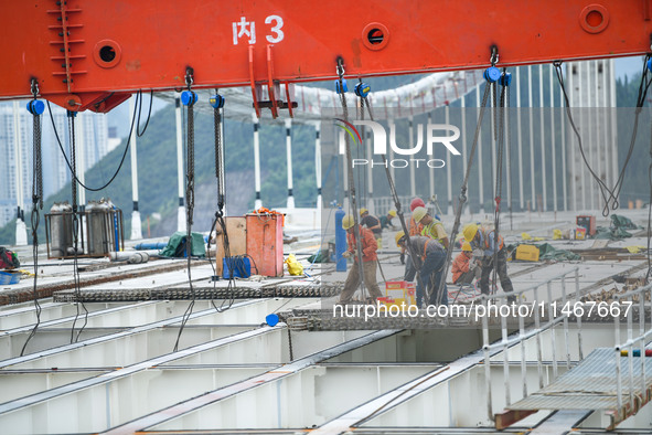 Workers are working at the construction site of Jinzhou Bridge in Xingyi, China, on August 11, 2024. 