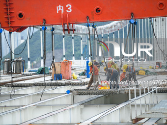 Workers are working at the construction site of Jinzhou Bridge in Xingyi, China, on August 11, 2024. (