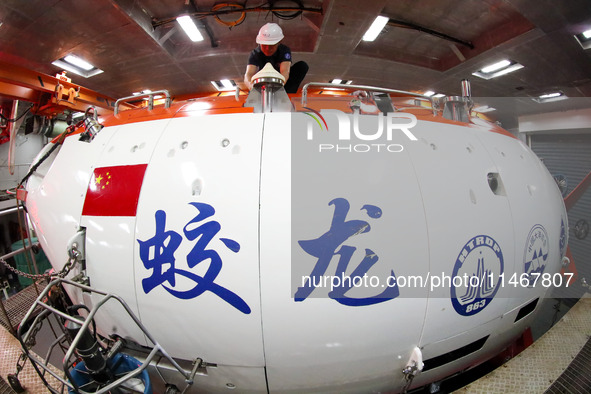 Members of the scientific expedition are inspecting the appearance and working condition of Jiaolong manned submersible's lifting safety pin...