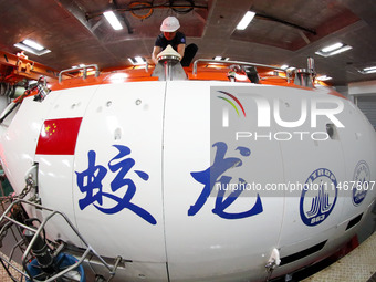 Members of the scientific expedition are inspecting the appearance and working condition of Jiaolong manned submersible's lifting safety pin...