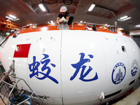 Members of the scientific expedition are inspecting the appearance and working condition of Jiaolong manned submersible's lifting safety pin...