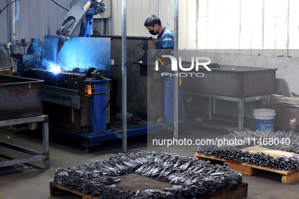 A worker of an enterprise is producing scissors on the production line at Yanshan Ocean Knife and Scissors Industrial Park in Zherong County...