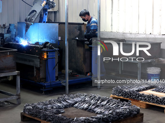 A worker of an enterprise is producing scissors on the production line at Yanshan Ocean Knife and Scissors Industrial Park in Zherong County...