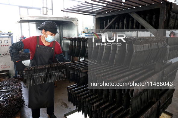 A worker of an enterprise is producing scissors on the production line at Yanshan Ocean Knife and Scissors Industrial Park in Zherong County...