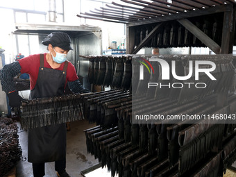 A worker of an enterprise is producing scissors on the production line at Yanshan Ocean Knife and Scissors Industrial Park in Zherong County...