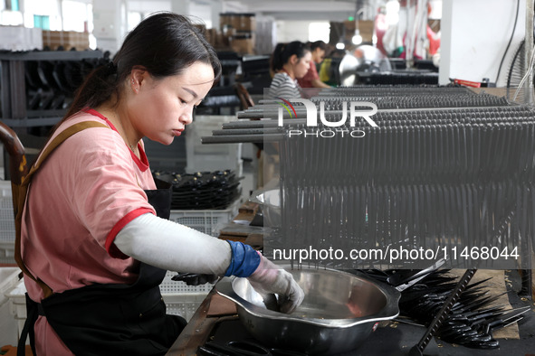 A worker of an enterprise is producing scissors on the production line at Yanshan Ocean Knife and Scissors Industrial Park in Zherong County...