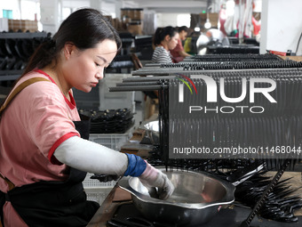 A worker of an enterprise is producing scissors on the production line at Yanshan Ocean Knife and Scissors Industrial Park in Zherong County...