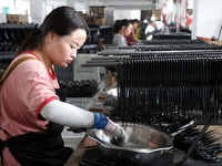 A worker of an enterprise is producing scissors on the production line at Yanshan Ocean Knife and Scissors Industrial Park in Zherong County...