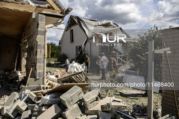 Local residents are cleaning up the residential building in a village in the Kyiv region, heavily damaged during a massive Russian missile a...