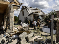 Local residents are cleaning up the residential building in a village in the Kyiv region, heavily damaged during a massive Russian missile a...