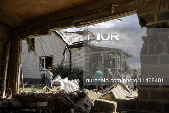 Local residents are cleaning up the residential building in a village in the Kyiv region, heavily damaged during a massive Russian missile a...