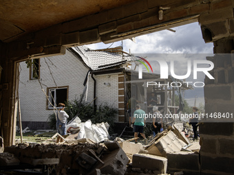 Local residents are cleaning up the residential building in a village in the Kyiv region, heavily damaged during a massive Russian missile a...