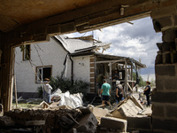 Local residents are cleaning up the residential building in a village in the Kyiv region, heavily damaged during a massive Russian missile a...