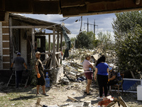 Local residents are cleaning up the residential building in a village in the Kyiv region, heavily damaged during a massive Russian missile a...