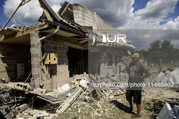 Local residents are cleaning up the residential building in a village in the Kyiv region, heavily damaged during a massive Russian missile a...